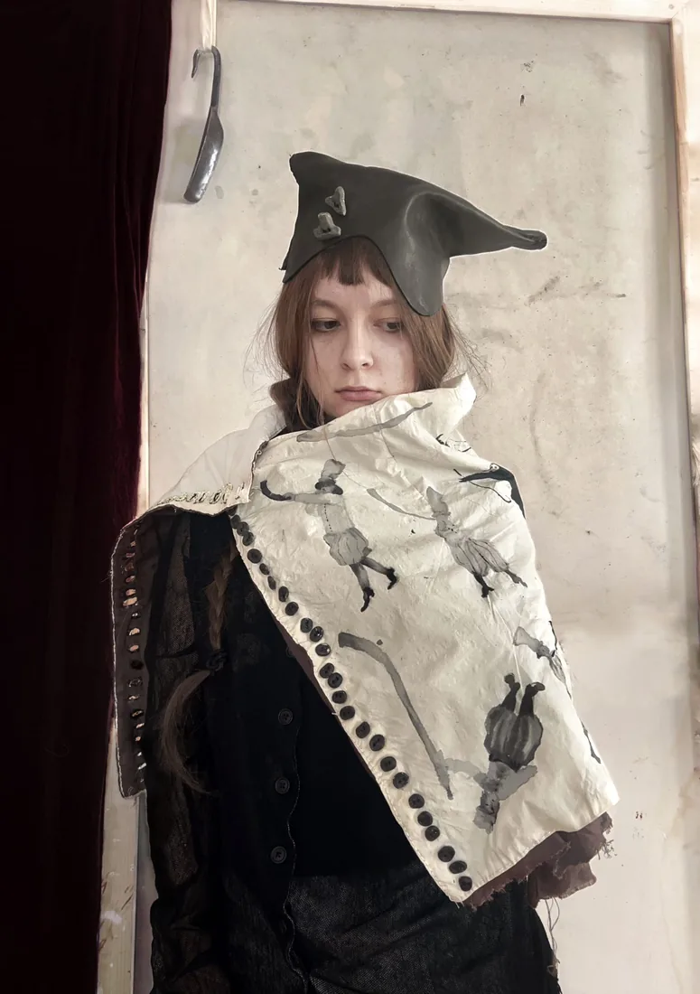"Lituus I" (Ligava) textile work by Veronika Horytska: hand-sewn cape with painted figures, worn